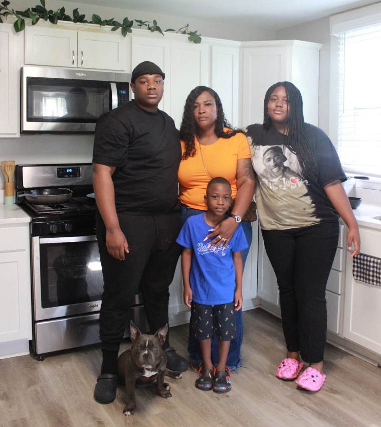 Shanika Henderson, center,  poses with her family, from left, 17yr old son Montique, 5yr old son Graceson, 12yr old daughter Kaylah, with Humphrey the dog.