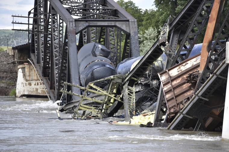 Several train cars are immersed in the Yellowstone River after a bridge collapse near Columbus, Mont., on Saturday, June 24, 2023.  (AP Photo/Matthew Brown)