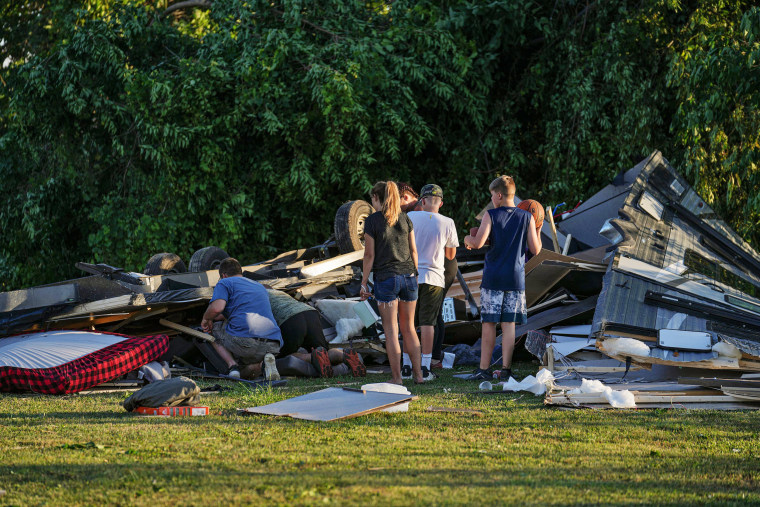 People survey what's left of an RV camper after a tornado touched down in several areas of Greenwood, Ind., on Sunday afternoon, June 25, 2023. 