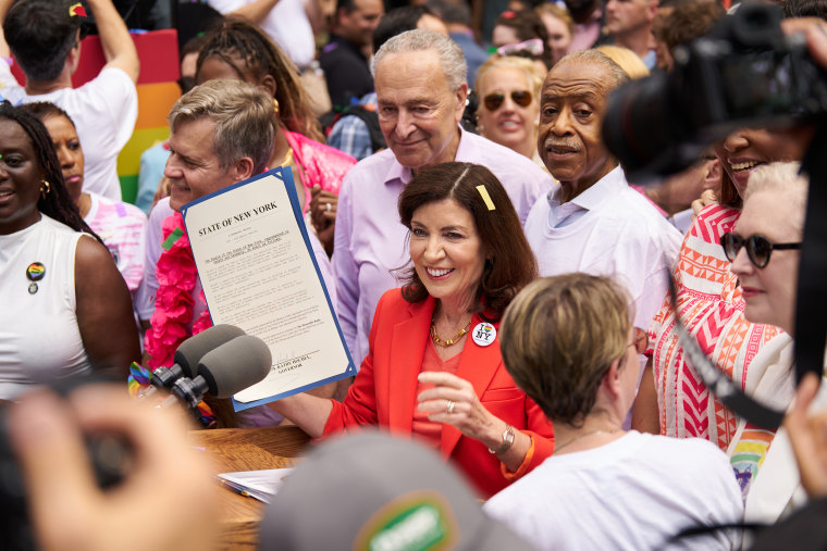 Gov. Kathy Hochul holding signed legislation designating New York state as a safe haven for trans youth and physicians before the NYC Pride March on June 25, 2023. 