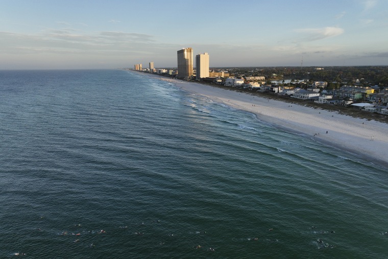 An aerial view of age group athletes competing in the swim course at IRONMAN Florida on November 05, 2022 in Panama City Beach, Florida.