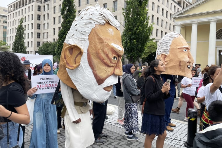 Protestors wear paper-m‌ache heads of President Joe Biden and Modi in Washington D.C. on June 22, 2023.