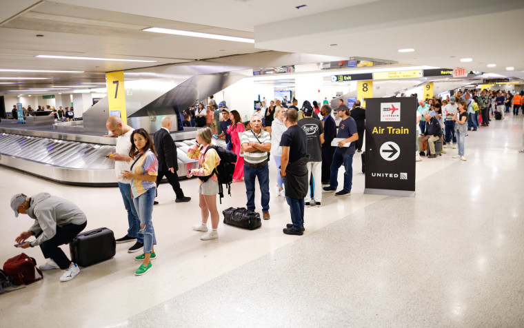 People wait to reschedule their flights at Newark International Airport, in Newark, N.J.