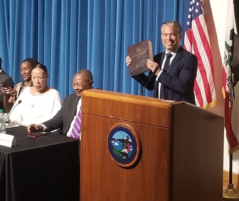 California attorney general Rob Bonta holds up the reparations report.