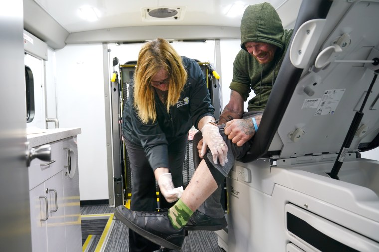 Registered nurse Kathy Lalli treats Ellwood Warren's injuries at the Kensington Hospital wound care outreach van, in Philadelphia