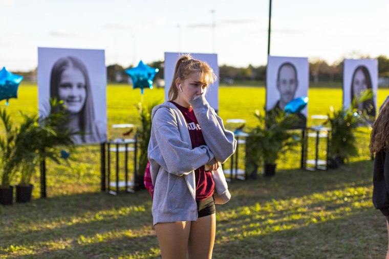 A woman visits a memorial for the victims of the Marjory Stoneman Douglas High School mass shooting in Parkland, Fla.