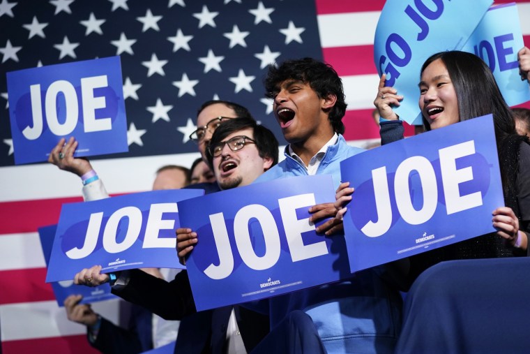 Supporters cheer as President Joe Biden speaks at the Democratic National Committee Winter Meeting