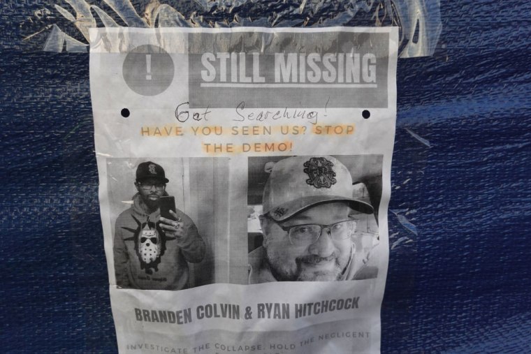 Un cartel con las fotos de Branden Colvin y Ryan Hitchcock, en el lugar del derrumbe del edificio en Davenport, Iowa.
