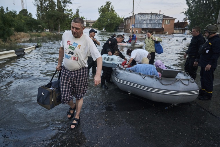 Rescatistas intentan remolcar botes para llevar a vecinos evacuados de un vecindario inundado en Kherson, Ucrania, el martes 6 de junio de 2023.