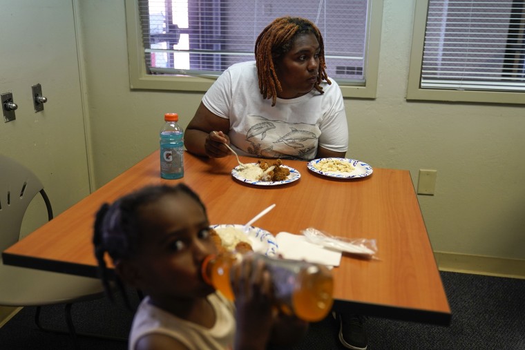 Toriana Hill, una inquilina que se salvó del derrumbe del edificio, almuerza junto a su hija en un refugio de la Cruz Roja en Davenport, Iowa, el miércoles.