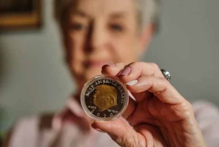 Una abuela de Alabama sostiene una de las monedas que compró por Internet en su apartamento de Mobile.