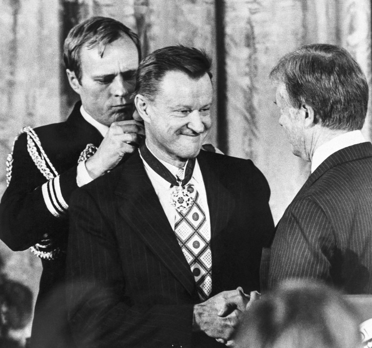 President Jimmy Carter schudt zijn nationale veiligheidsadviseur Zbigniew Brzezinski de hand terwijl hij Brzezinski de Medal of Freedom overhandigt tijdens een ceremonie in het Witte Huis op 17 januari 1981.