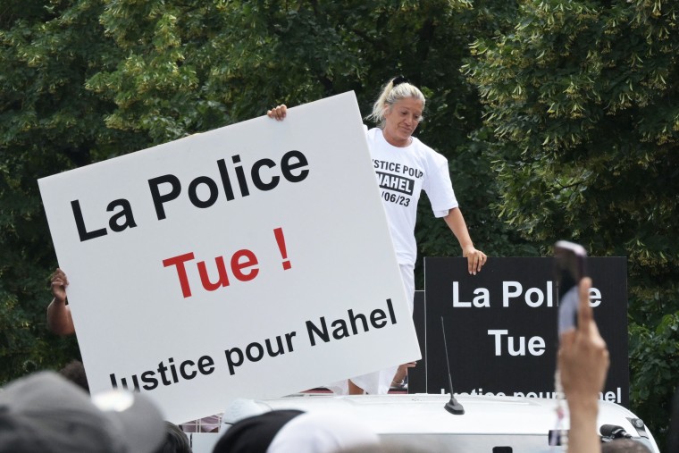 Mounia M. stands atop a truck during a commemoration march for her son in Nanterre, Paris