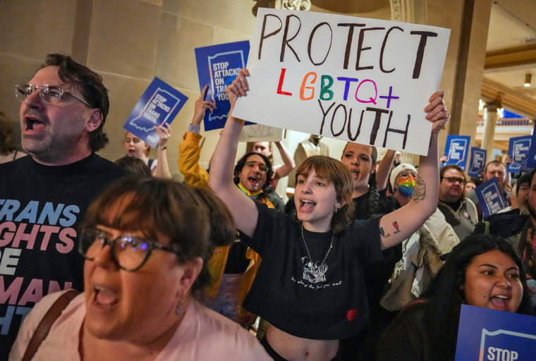 Eliza Housman, center, and others protest outside the Indiana Senate Chamber on Feb. 22, 2023, against a bill which would ban gender-affirming medical or surgical treatment for minors.
