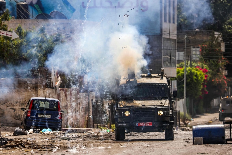 Israeli soldiers fire tear gas canisters from an armored vehicle during an ongoing military operation in the occupied West Bank city of Jenin on July 4, 2023.