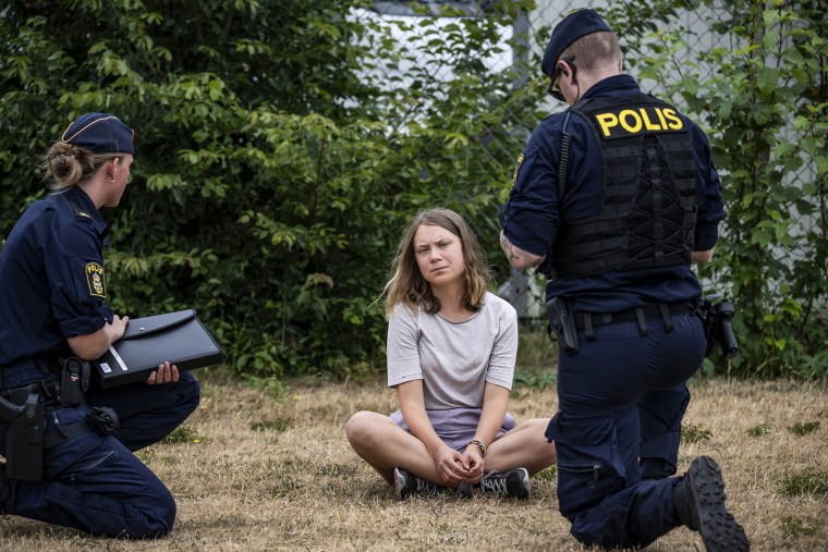 Police officers talk to climate activist Greta Thunberg as they move activists from the organization "Take back the future" who are blocking the entrance to the Oljehamnen neighbourhood in Malmo, Sweden, on June 19, 2023.