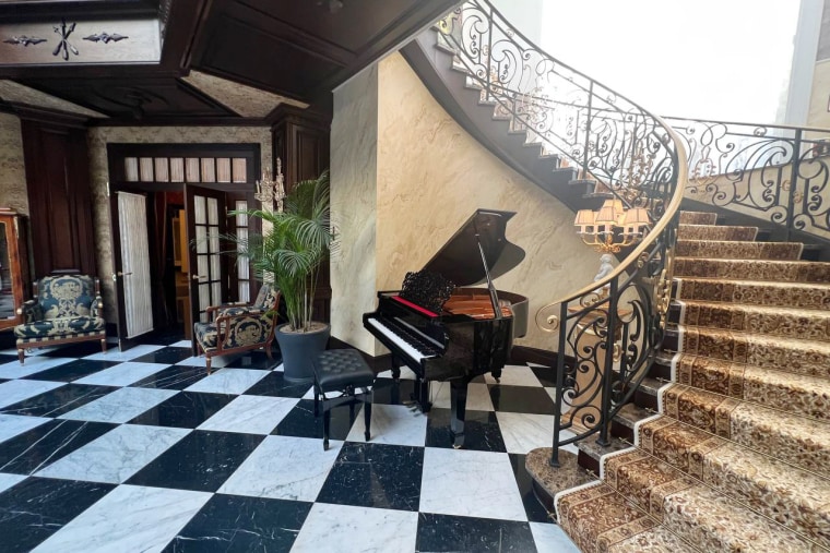 A grand staircase leads down to a piano on a marble floor in what appears to be the entrance of Yevgeny Prigozhin's home in St. Petersburg.