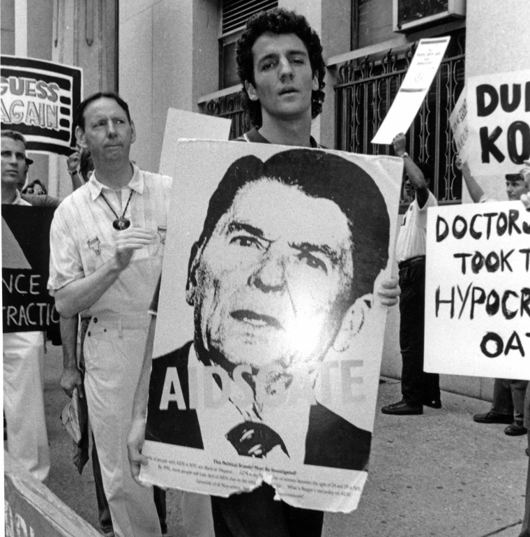 Um ativista da AIDS segura uma foto do presidente Ronald Reagan durante uma manifestação em 28 de julho de 1988 no Departamento de Saúde da cidade de Nova York. 