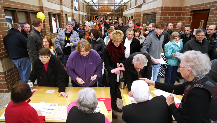 Republican voters register before taking part in caucuses in Carroll, Iowa