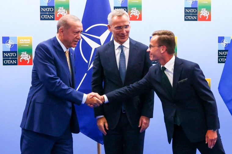 Turkish President Tayyip Erdogan, left, and Swedish Prime Minister Ulf Kristersson shake hands next to NATO Secretary-General Jens Stoltenberg on the eve of a NATO summit in Vilnius, Lithuania, on July 10, 2023.