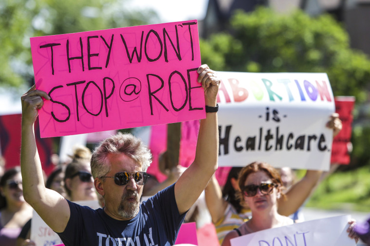 Image: A man holds a sign as community members walk around Vander Veer Park in Davenport, Iowa, during a march following the U.S. Supreme Court decision to overturn Roe v. Wade on June 26, 2022.