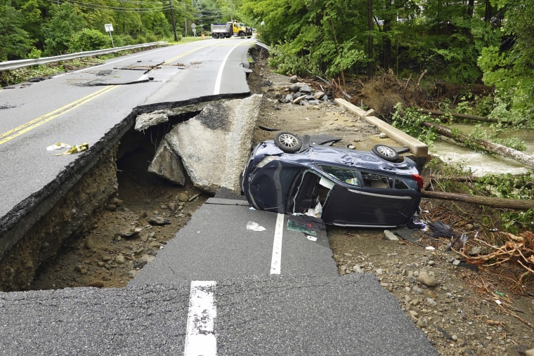 A damaged car lies on a collapsed part of Route 32 in the Hudson Valley near Cornwall, N.Y., on Monday.