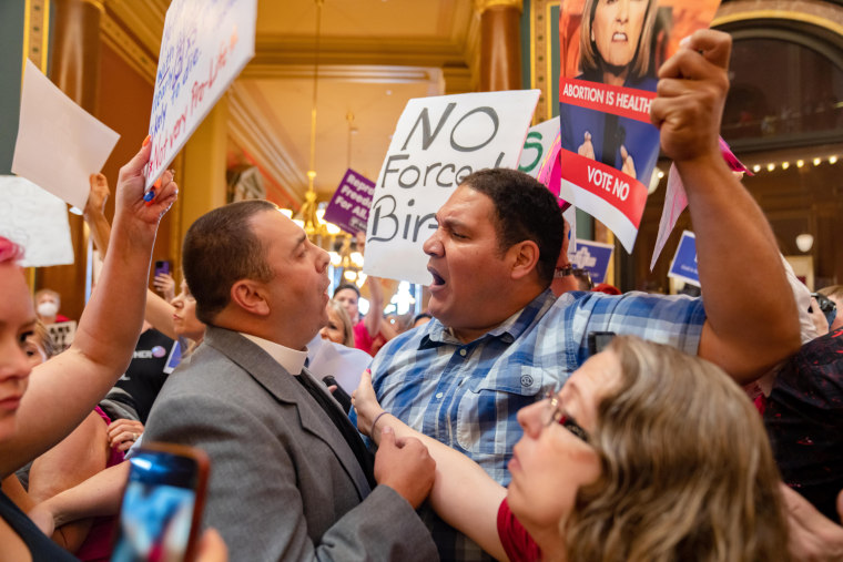 The Rev. Michael Shover of Christ the Redeemer Church in Pella, left, argues with Ryan Maher, of Des Moines as anti-abortion and abortion rights protesters clash in the Iowa Capitol rotunda on July 11, 2023.