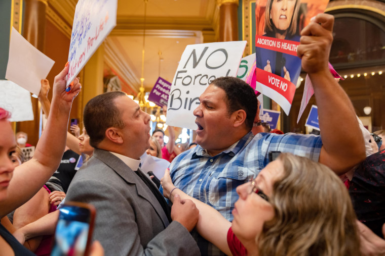 The Rev. Michael Shover of Christ the Redeemer Church in Pella, left, argues with Ryan Maher of Des Moines as anti-abortion and abortion rights protesters face off in the Capitol rotunda of Iowa on July 11, 2023.