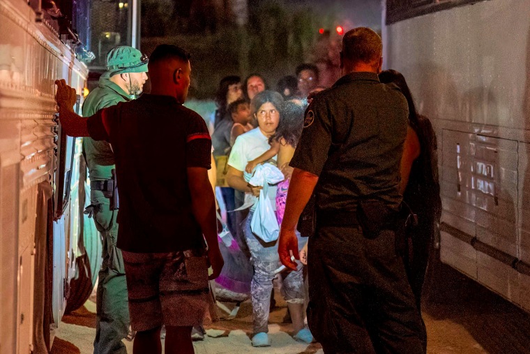 Border Patrol agents escort migrants onto a bus to be taken to a processing facility to begin their asylum-seeking process in Eagle Pass, Texas, on June 25, 2023.