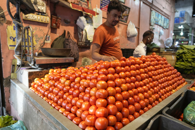 A vendor arranges tomatoes at a vegetable market in Ahmedabad, India, Tuesday, July 11, 2023.