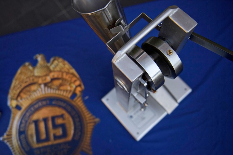 A seized pill press machine is displayed at a DEA news conference in Los Angeles in 2021.