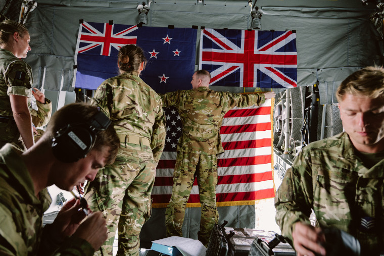 Las fuerzas británicas cuelgan la bandera estadounidense debajo de las banderas de Nueva Zelanda y Gran Bretaña dentro de un Airbus A400M en Hickam Field en Honolulu,