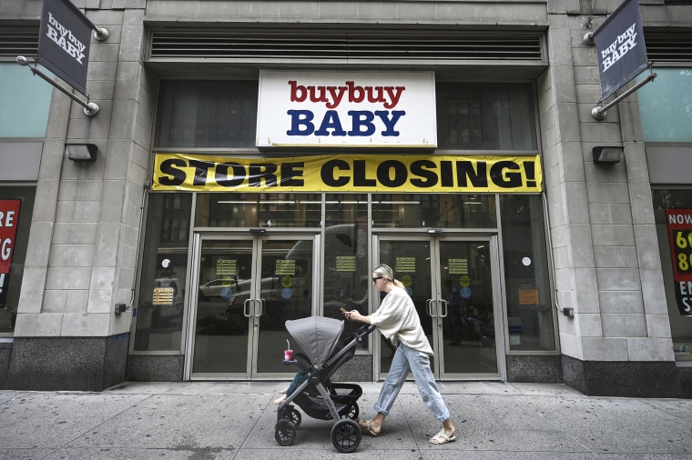 A woman pushes a stroller past a' buybuy Baby' retail store in New York on July 12, 2023.