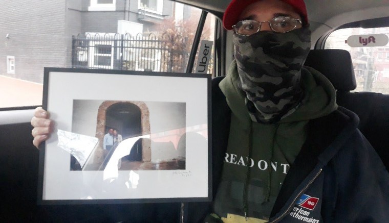 Kevin Lyons with a framed photo of Nancy Pelosi and John Lewis from Pelosi's office on January 6, 2021.