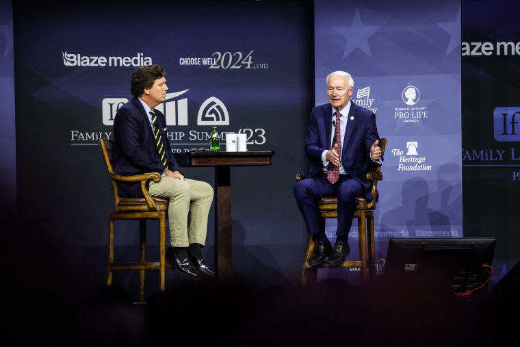 Image: Former Fox News Television personality Tucker Carlson and Republican presidential candidate, former Arkansas Gov. Asa Hutchinson speak to guests at the Family Leadership Summit on July 14, 2023 in Des Moines, Iowa. 
