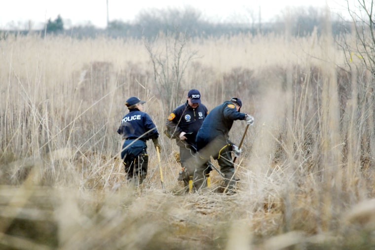 FILE - Crime scene investigators use metal detectors to search a marsh for the remains of Shannan Gilbert, Dec. 12, 2011 in Oak Beach, New York. A Long Island architect has been charged, Friday, July 14, 2023, with murder in the deaths of three of the 11 victims in a long-unsolved string of killings known as the Gilgo Beach murders. (James Carbone/Newsday via AP, Pool, File)