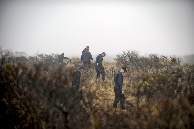 Police investigators search for human remains on Long Island's shoreline near Gilgo Beach on April 11, 2011. 