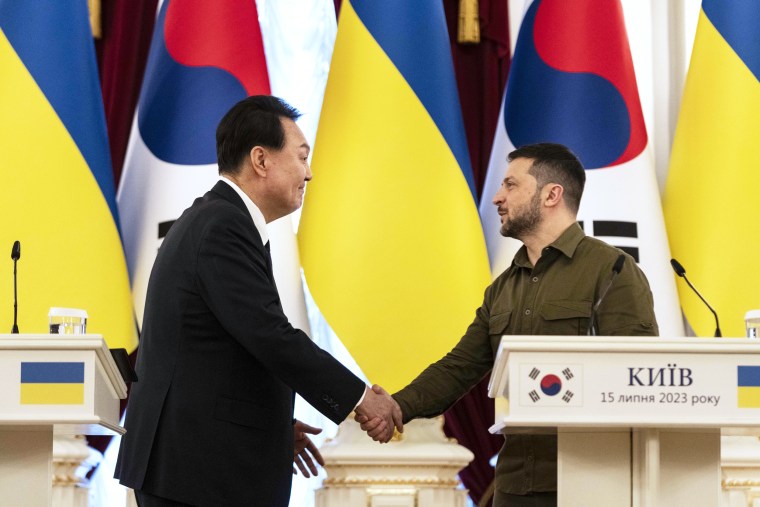 El presidente de Corea del Sur, Yoon Suk Yeol, y el presidente de Ucrania, Volodymyr Zelensky, se dan la mano