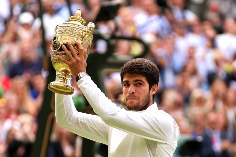Carlos Alcaraz lifts trophy after defeating Novak Djokovic at Wimbledon on July 16, 2023, in London.