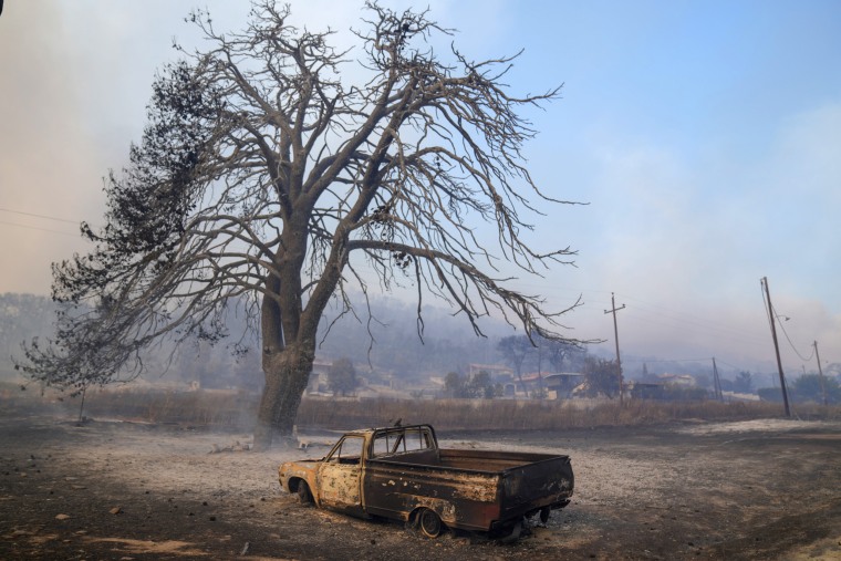 A car burned in a wildfire in Loutraki, some 50 miles west of Athens, Greece, Monday, July 17, 2023.