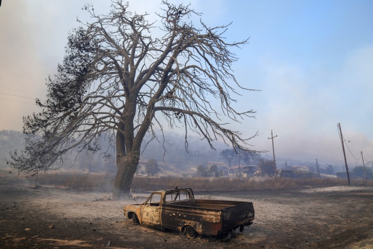 A car burned in a wildfire in Loutraki, some 50 miles west of Athens, Greece, Monday, July 17, 2023. 