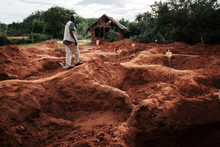 An officer of the Directorate of Criminal Investigations (DCI) walks at the mass-grave site in Shakahola, outside the coastal town of Malindi, on April 25, 2023. The death toll in an investigation linked to a Kenyan cult that practised starvation to "meet Jesus Christ" has exceeded 400 after 12 new bodies were found on July 17, 2023, a senior official said.