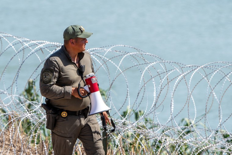 A Texas Department of Public Safety (DPS) highway patrol trooper looks over the Rio Grande at the US-Mexico Border on July 15, 2023 in Eagle Pass, Texas. The buoy installation is part of an operation Texas is pursuing to secure its borders, but activists and some legislators say Governor Greg Abbott is exceeding his authority.