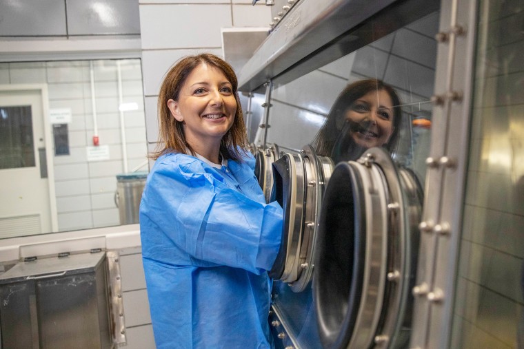 Dr. Mandy Cohen attempts to manipulate scientific equipment in a Class III biological safety cabinet in a training facility at the CDC's main campus in Atlanta on Thursday.