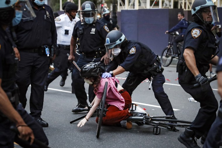 A protester is held, surrounded by police officers, while being arrested by NYPD in a New York street