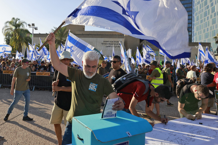 An Israeli military reservist drops a signed declaration in a box in Tel Aviv on July 19, 2023. The declaration announces the suspension of his voluntary reserve duty to protest the government's judicial overhaul bill.
