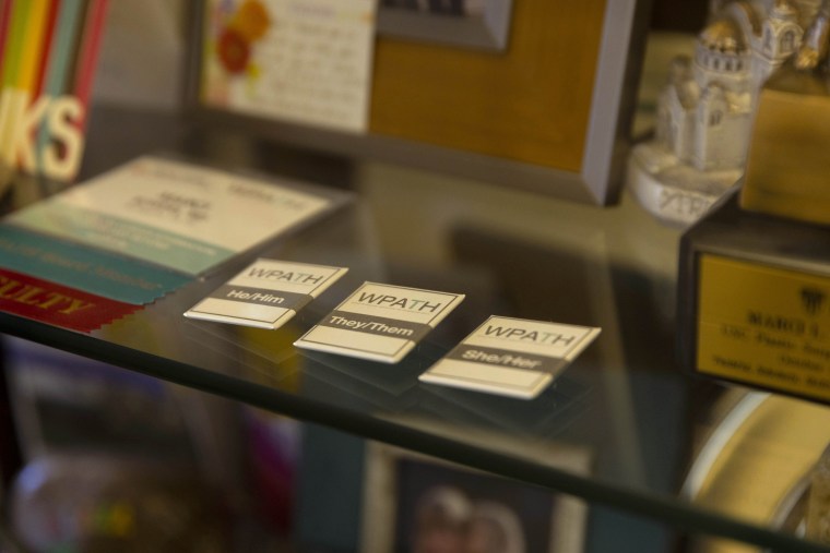 Pronoun pins in Dr. Marci Bowers’ office.