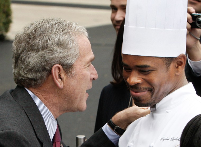 President Bush talks with one of the White House Chefs Tafari Campbell after making  remarks on the transition to administration employees, Thursday, Nov. 6, 2008, on the South Lawn of the White House in Washington.