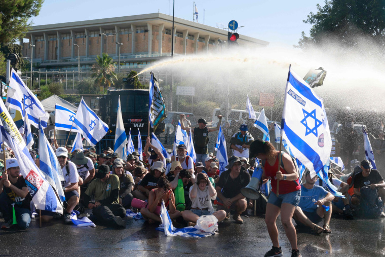 Las fuerzas de seguridad israelíes utilizan un cañón de agua para dispersar a los manifestantes que bloquean la entrada al Kensset, el parlamento de Israel, en Jerusalén, en medio de una ola de protestas de meses contra la reforma judicial planificada por el gobierno.