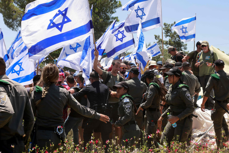 Los manifestantes ondean la bandera de Israel durante una manifestación cerca de la Knesset en Jerusalén.